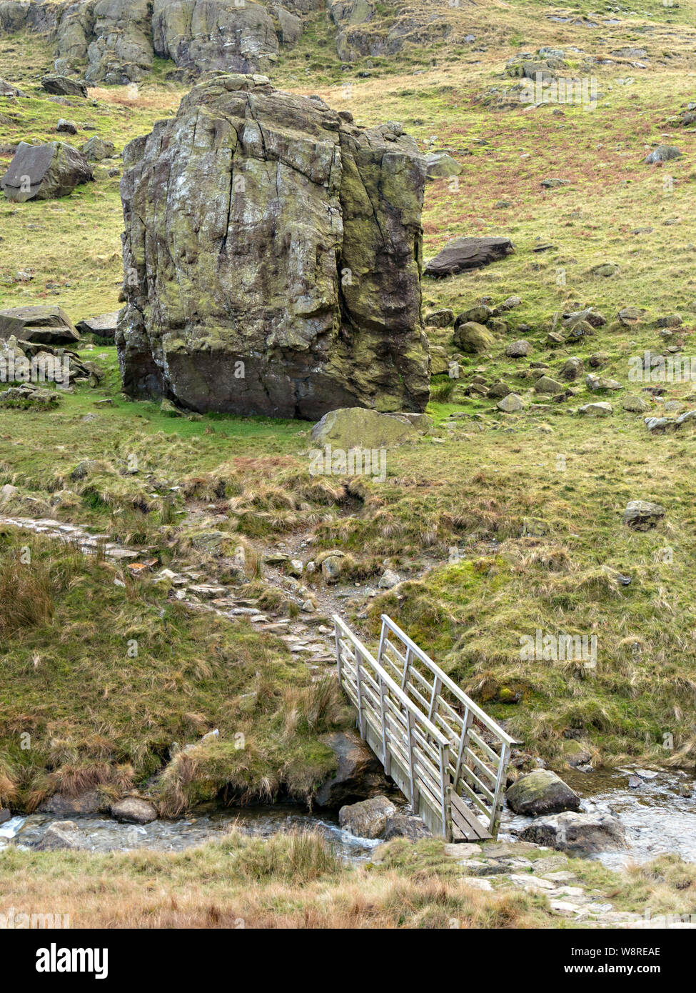 Footbridge and the huge "Pudding Stone" boulder in Boulder Valley on Coniston Fell, Lake