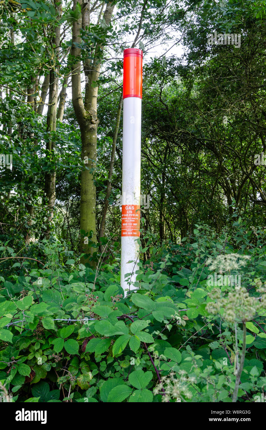 A marker at the edge of a field which marks the route of a gas main pipe. Stock Photo