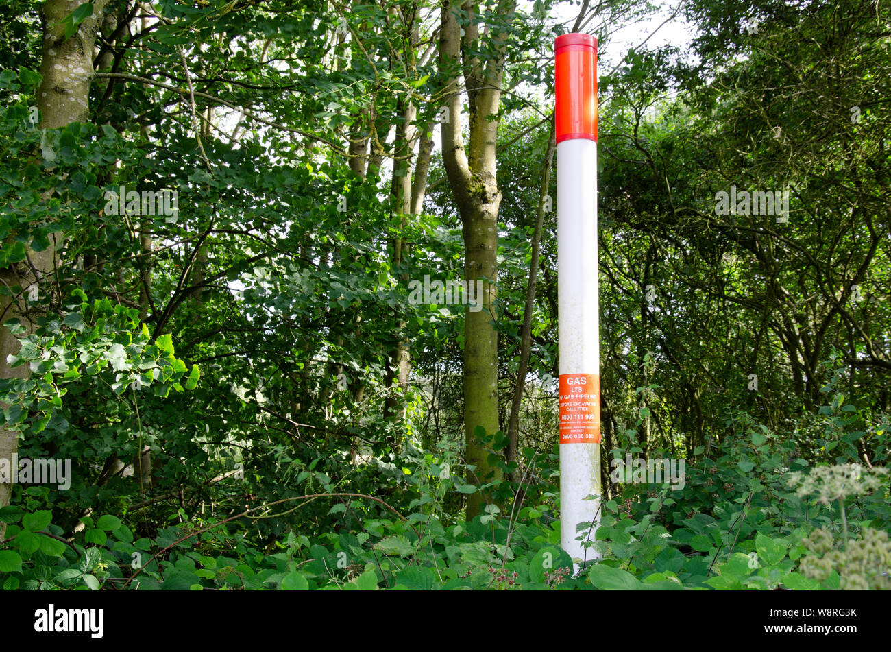 A marker at the edge of a field which marks the route of a gas main pipe. Stock Photo