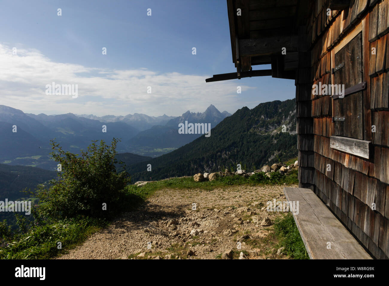 A Bench standing in front of a wooden cabin in the french alps in the Background a beautiful mountain panorama Stock Photo