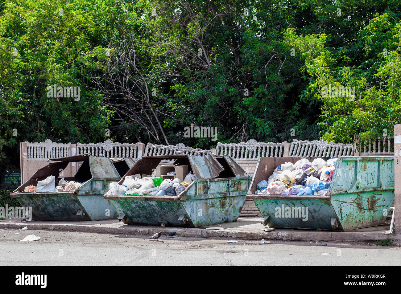Full trash bins in a city. Garbage cans in a town Stock Photo