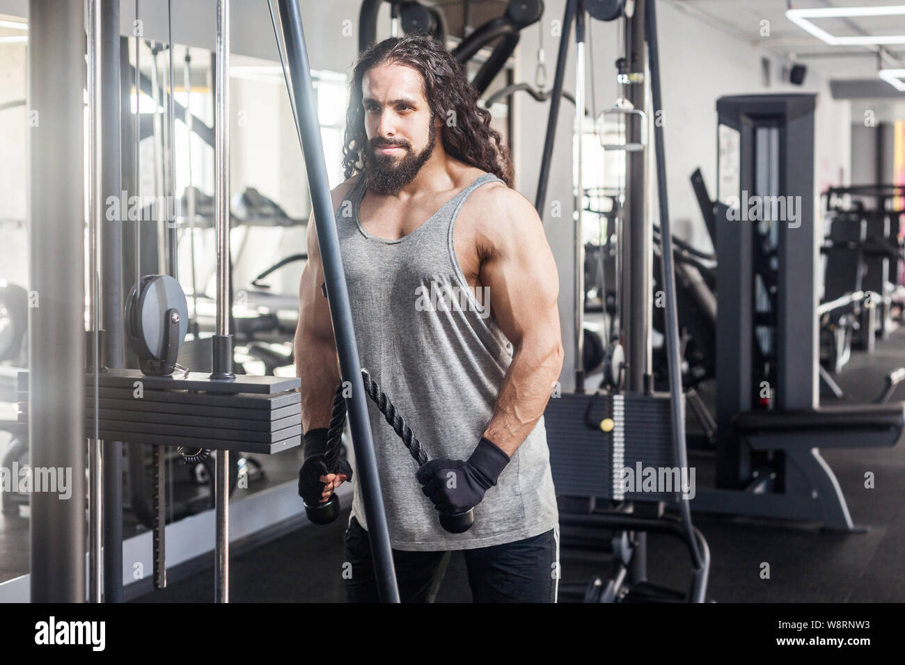Portrait of young adult sport athlete man with long curly hair training