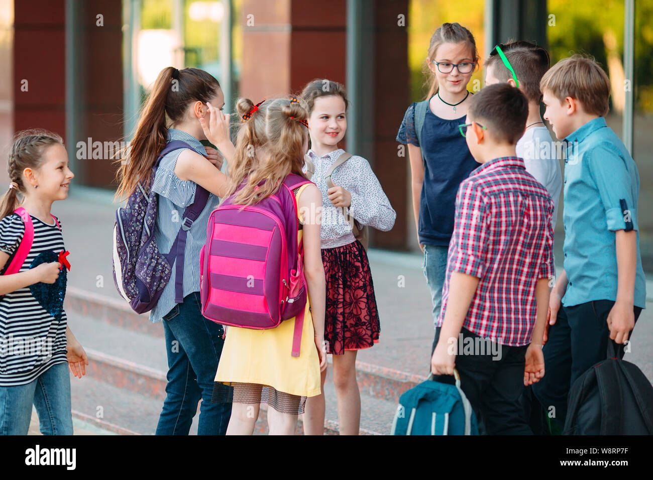 Schoolmates go to school. Students greet each other. Stock Photo