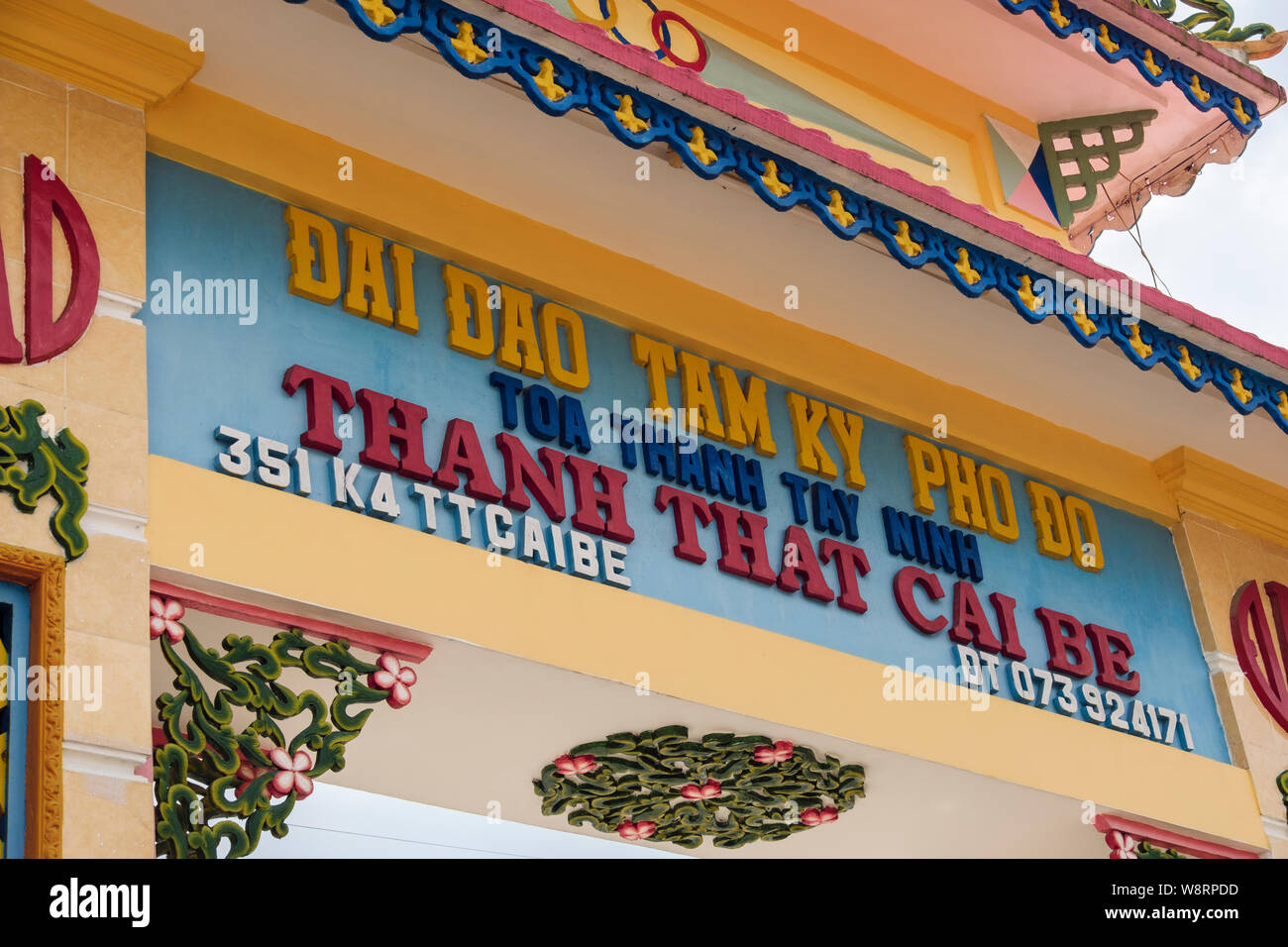 Inscription writing above colourful entrance to Cao Dai temple (Thánh Thất Cái Bè) for Caodaism faith. Cai Be, Tien Giang Province, southern Vietnam Stock Photo