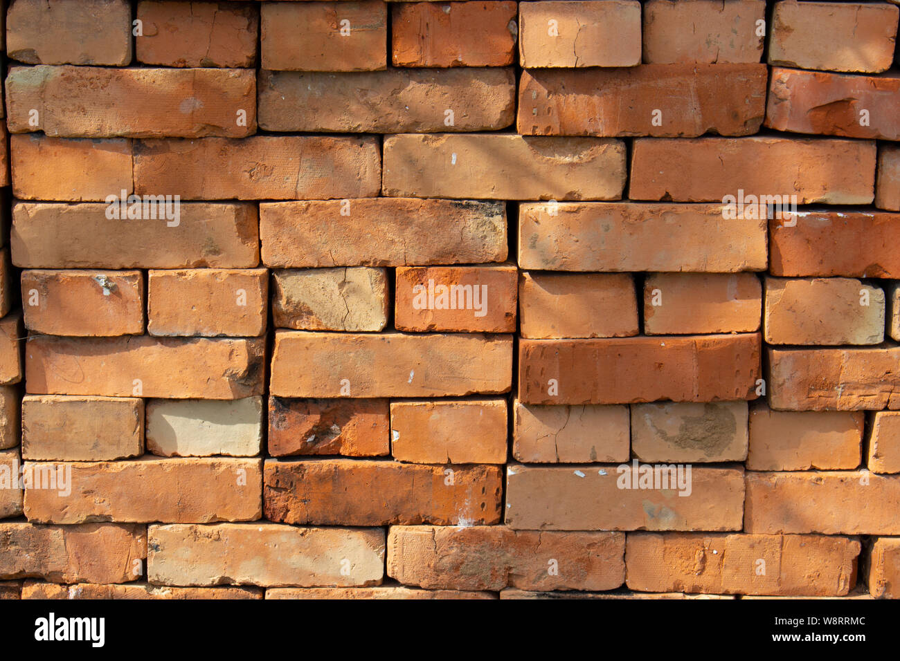 Red brick stack, background texture pattern. A pile of bricks material