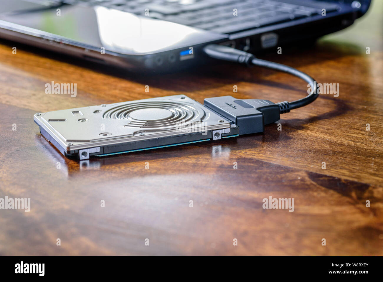 Connect Internal Laptop Hard Drive to USB: Effortless Guide 1 hdd 25 internal hard drive disk connected to laptop via sata usb cable on wooden table closeup view W8RXEY Connect Internal Laptop Hard Drive to USB: Effortless Guide