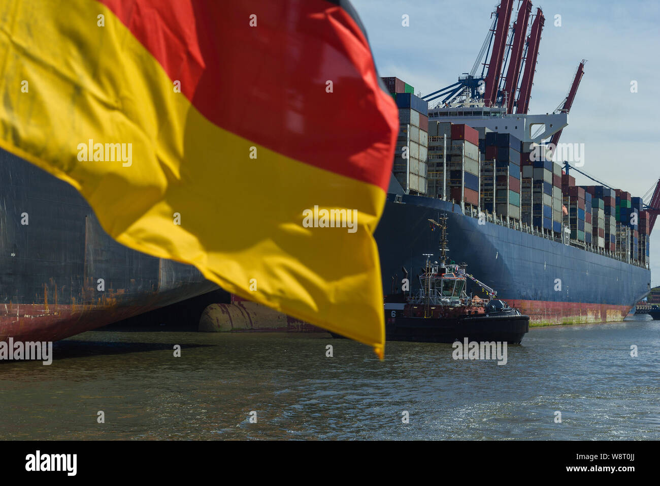 Container ship at container terminal Germany flag export free trade economy Stock Photo