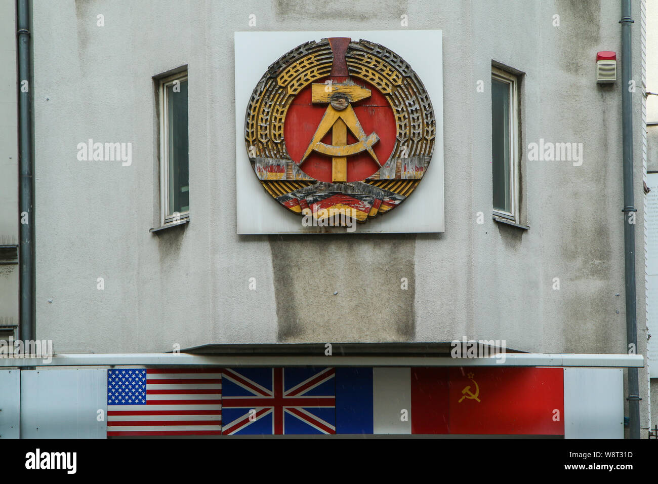 The detail of the sign of the German democratic republic on one of the houses at Check point Charlie in Berlin. Stock Photo