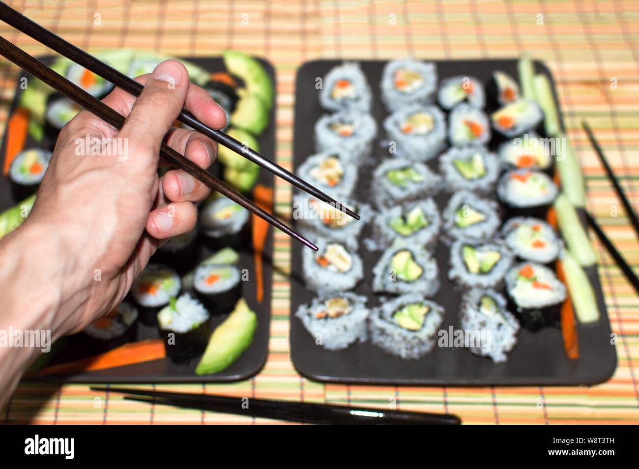 Hand Using Chopsticks With Background Full Of Different Types Of