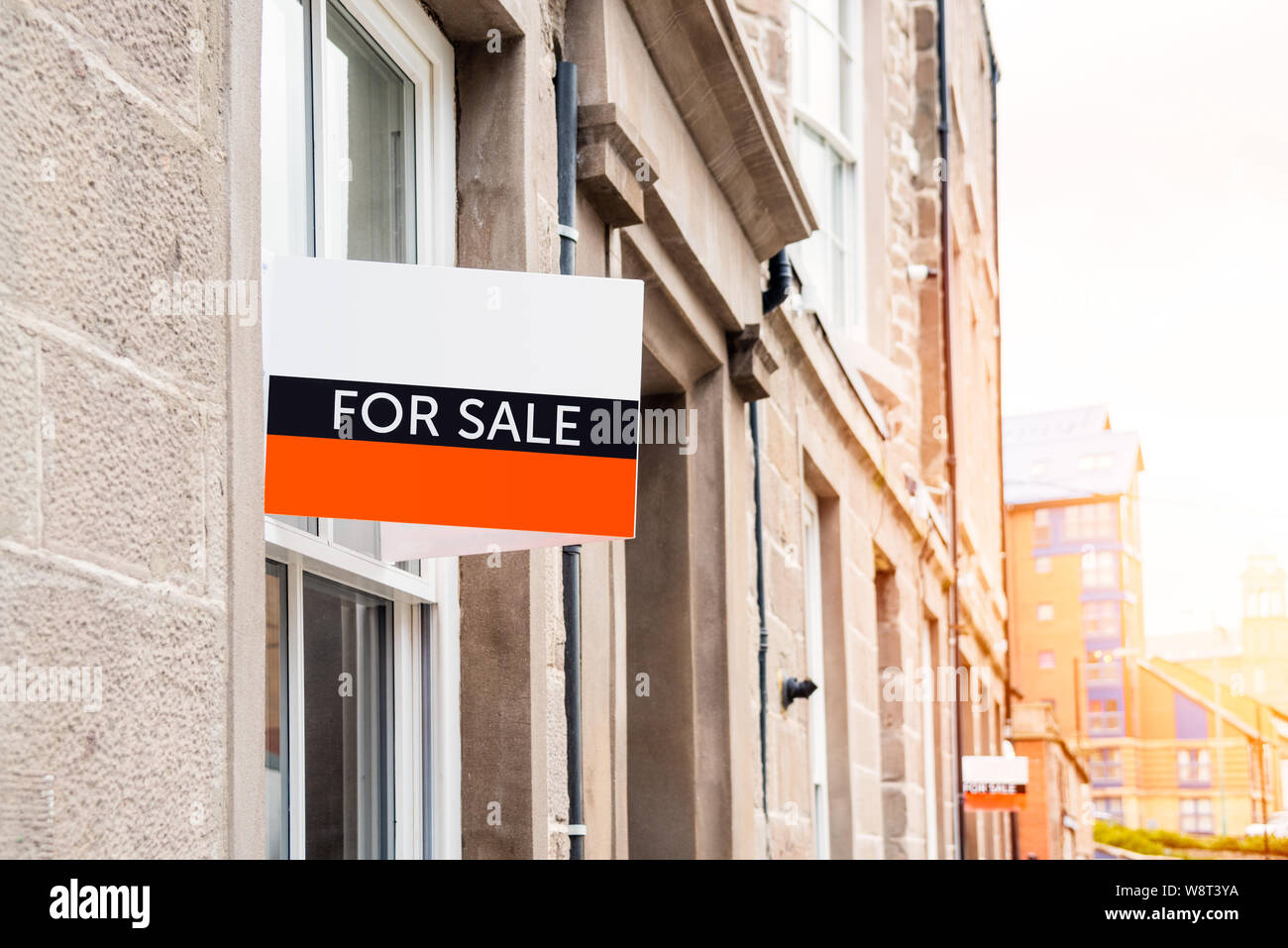 For sale sign on the exterior of a renovated aparment building in a city centre on asunny winter day Stock Photo