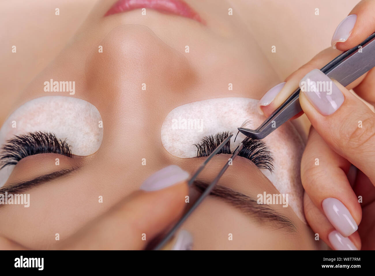 Eyelash Extension Procedure. Woman Eye with Long Blue Eyelashes. Ombre effect. Close up, selective focus. Stock Photo