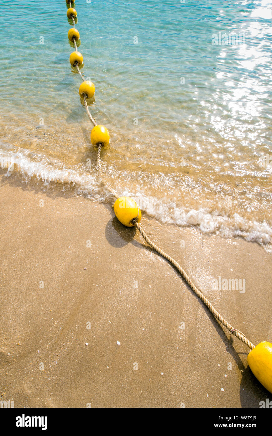 Floating buoy and rope dividing the area on the beach Stock Photo - Alamy