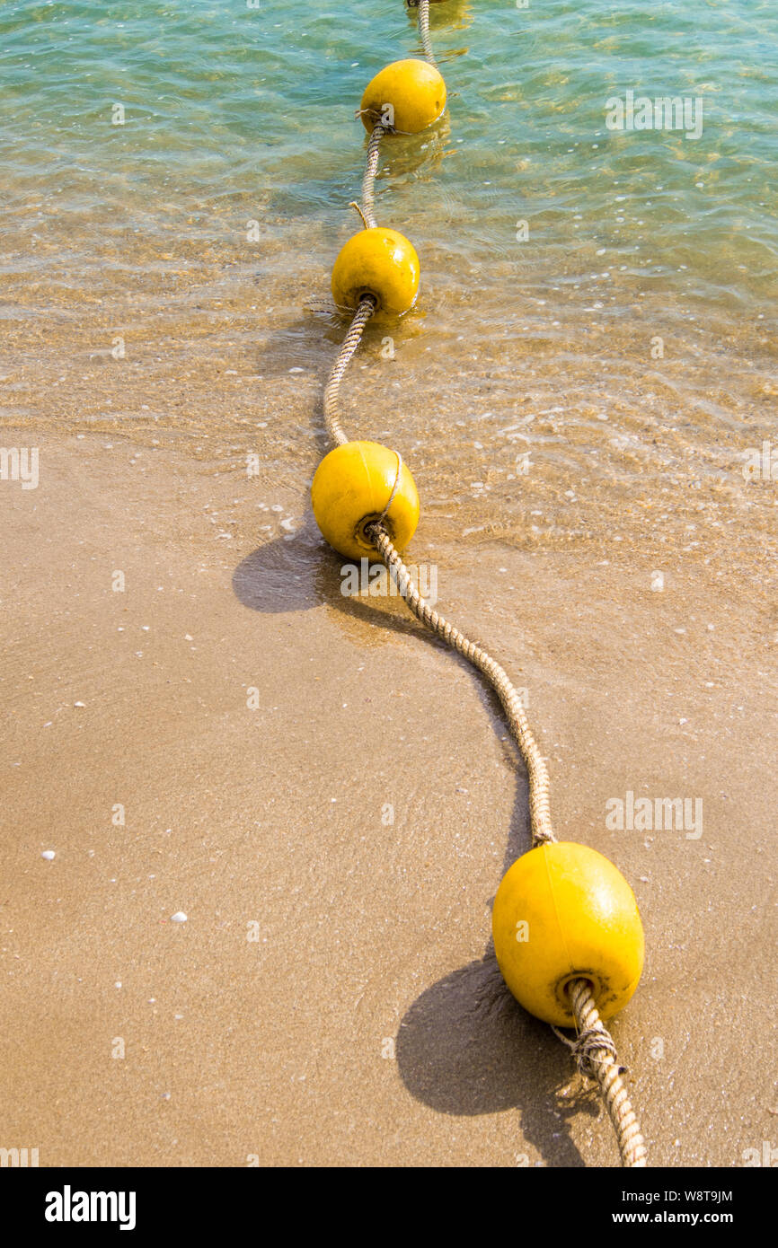 Floating buoy and rope dividing the area on the beach Stock Photo - Alamy