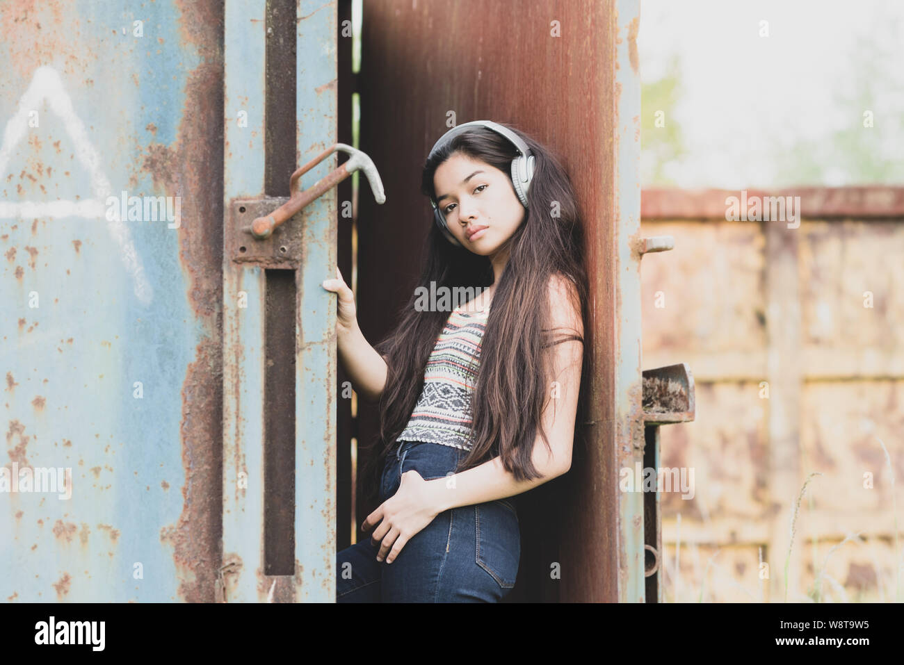 young beautiful asian woman wearing headphones outdoors Stock Photo
