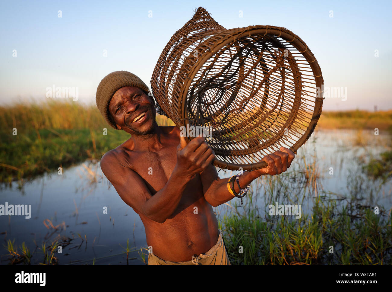 Fisherman carries a fish trap on the waterfront of Lake Malawi. Malawi is one of the poorest countries in the world. Stock Photo