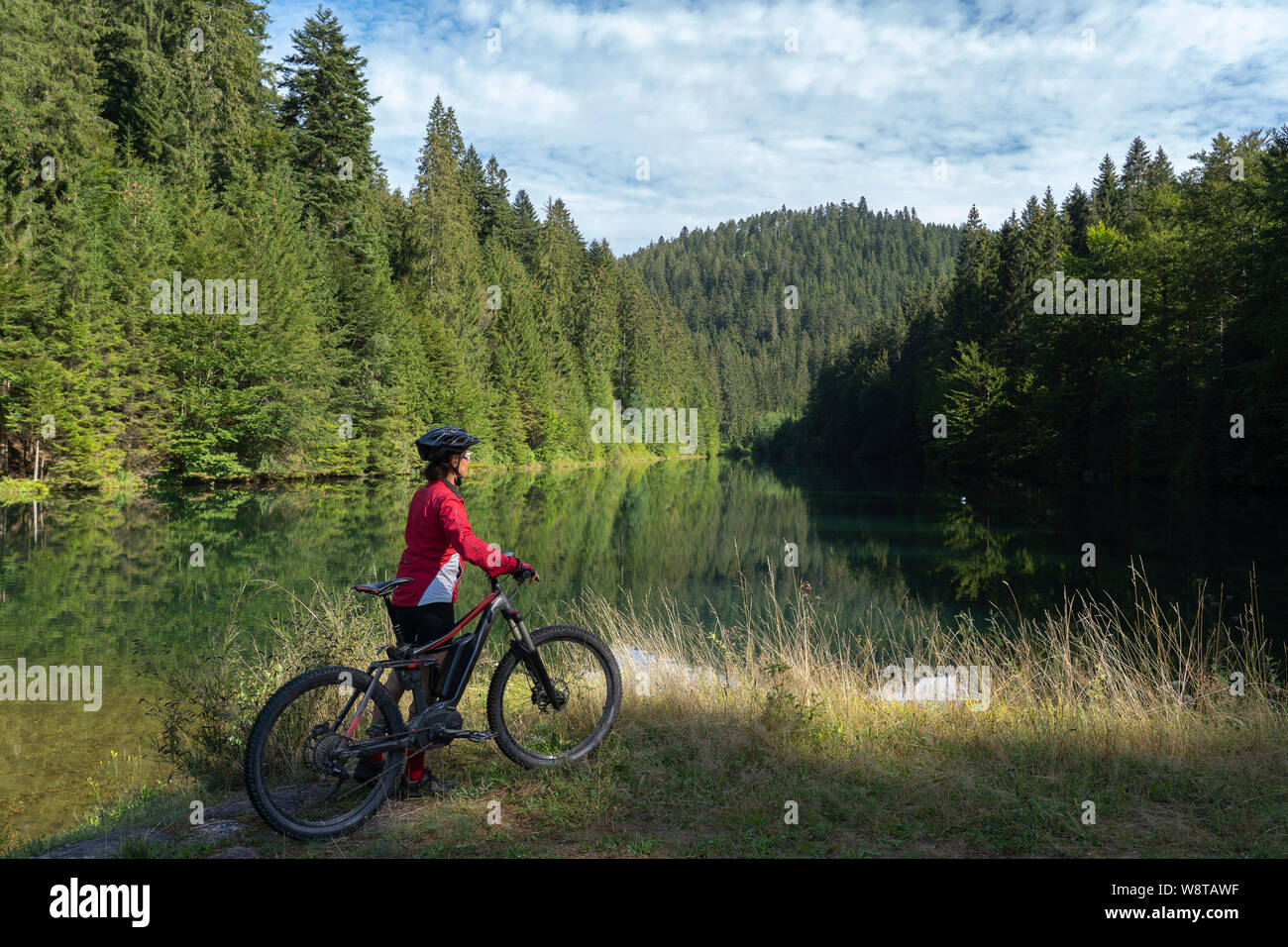 nice and ever young senior woman with her electric mountain bike at the Kinzig drinking Water reservoir in the northern Black Forest, Baden-Wuerttembe Stock Photo