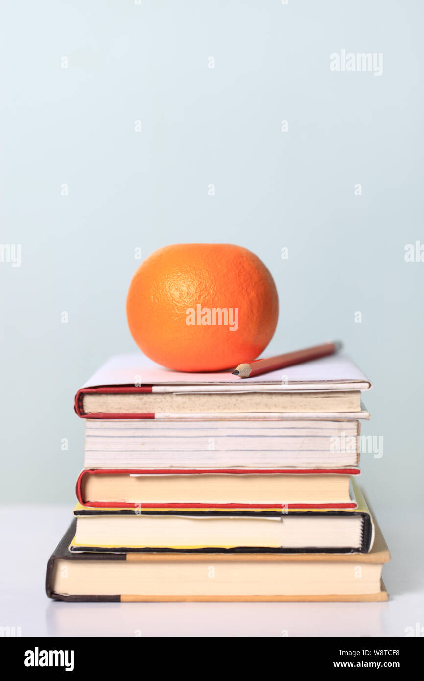 Orange on a stack of books Stock Photo