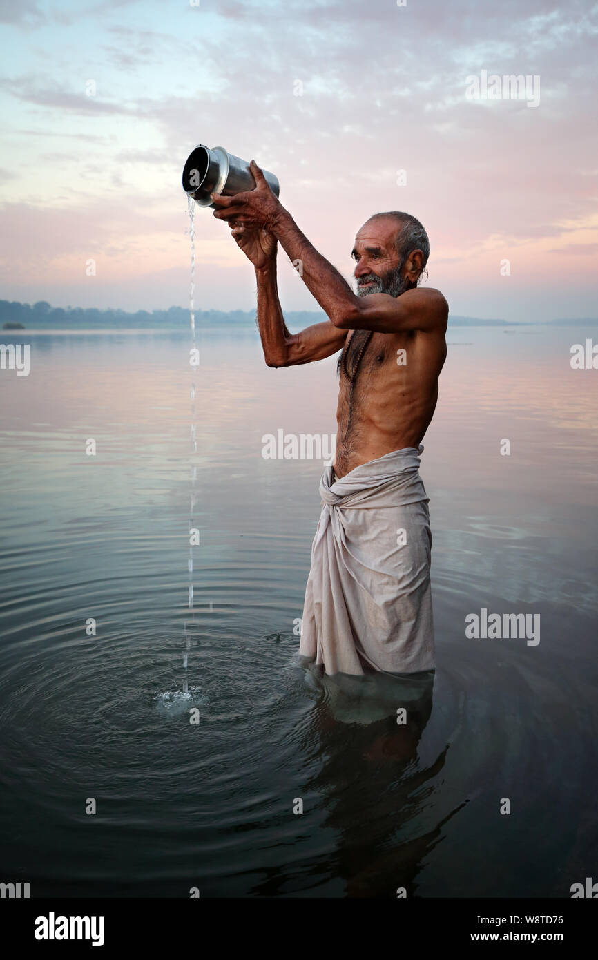 Hindu pilgrim prays and takes a holy bath in the sacred river Narmada ...