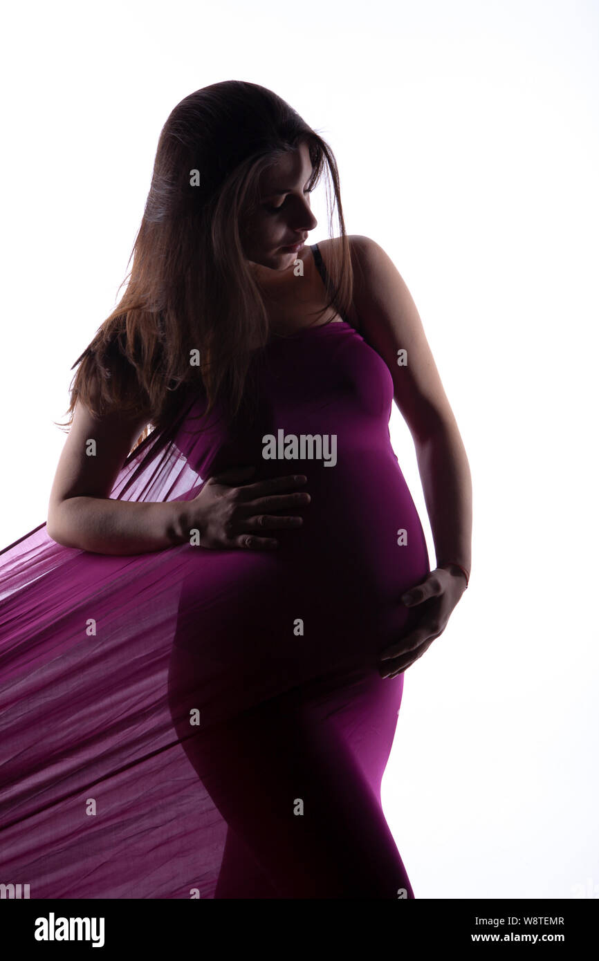Studio shots of pregnant woman in purple fabric. Stock Photo