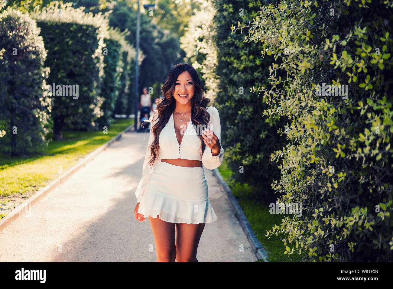 Beautiful Asian girl in white dress smiling in the park Stock Photo - Alamy