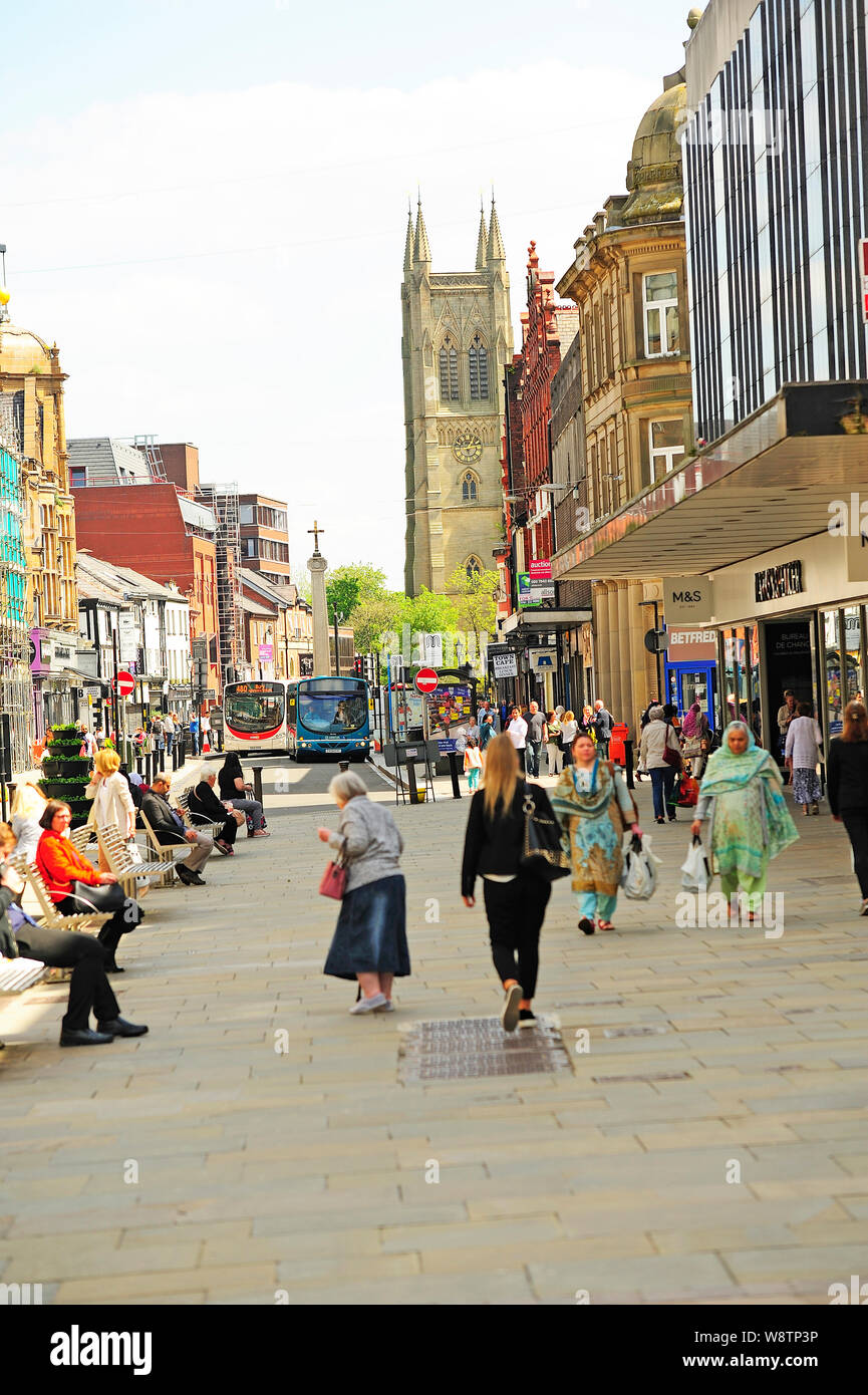 A busy Bolton town centre with the tower of St Peter's parish church in