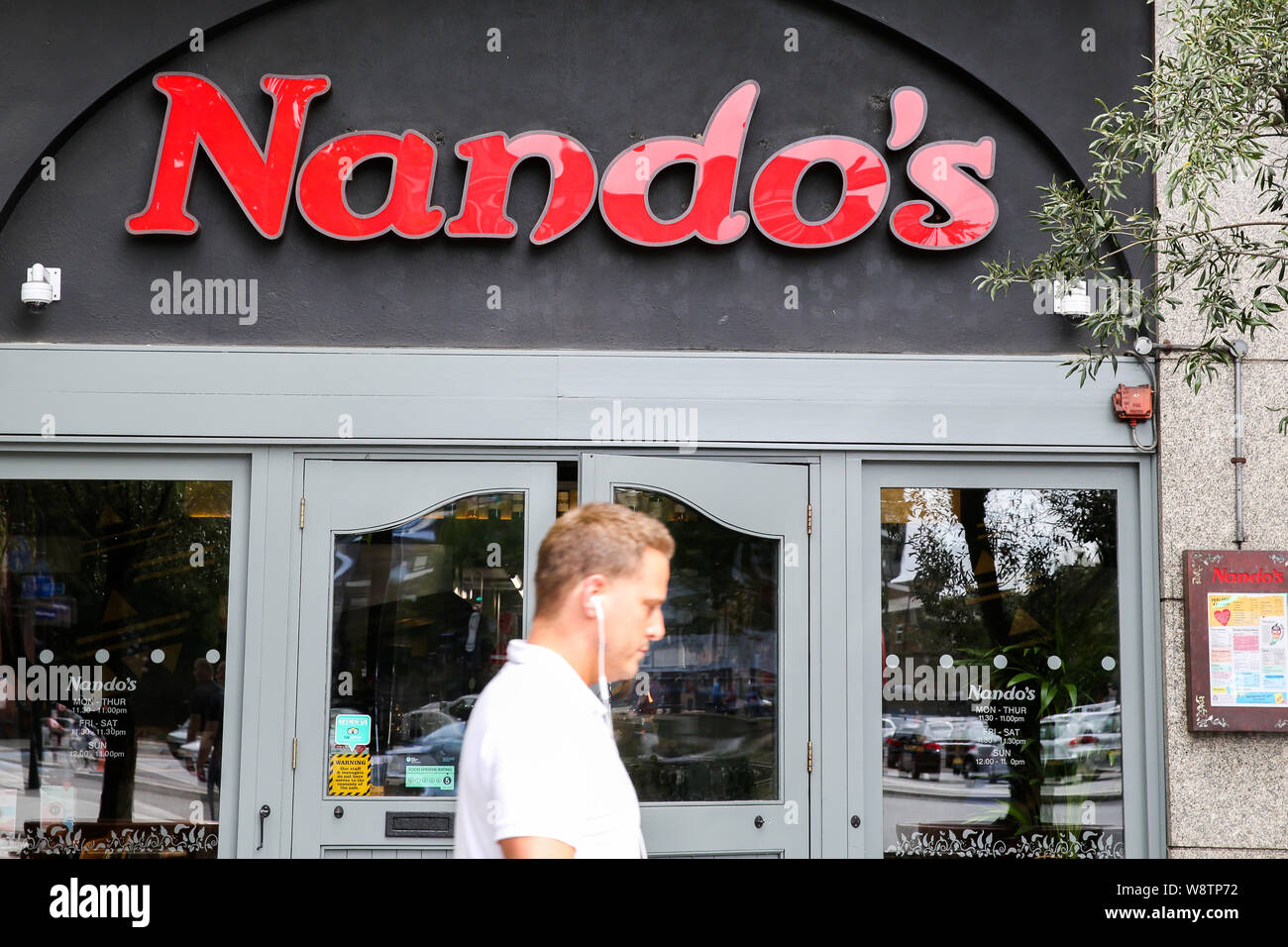 August 11 2019 London United Kingdom A Man Is Seem Walking Past A Branch Of Nando S
