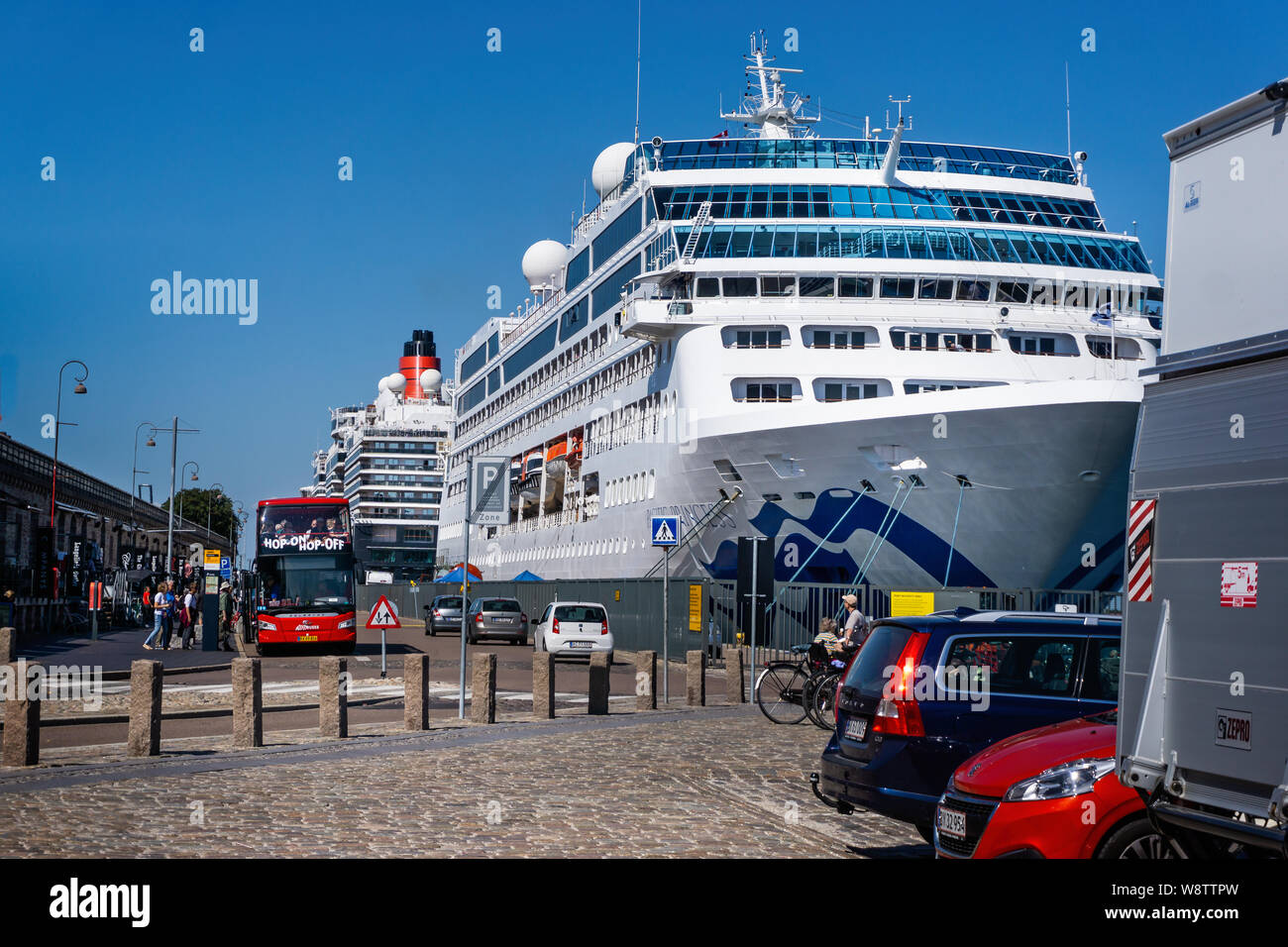 Pair of large Cruise Ships including Cunards Queen Victoria moored at Copenhagen, Denmark with hop on hop off tour bus on 18 July 2019 Stock Photo