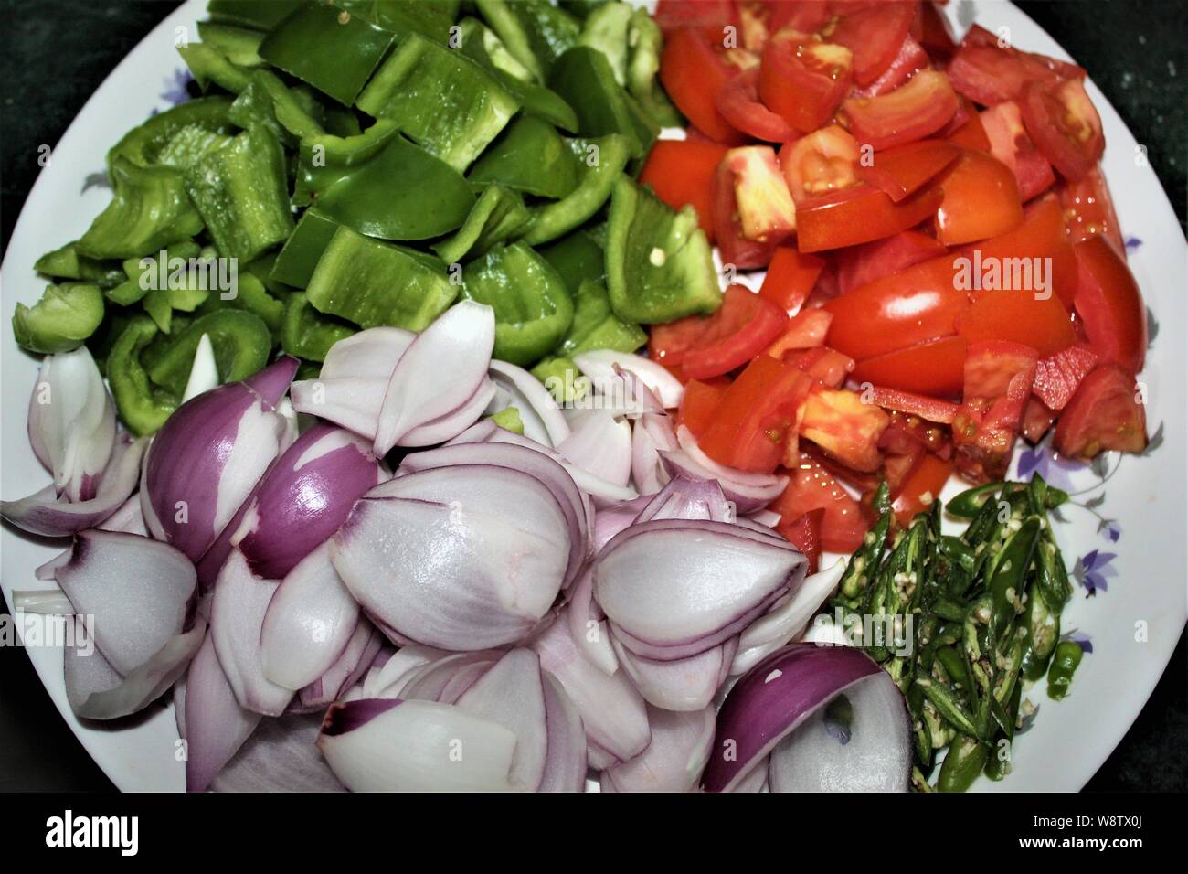 close up view of chopped vegetables like tomatoes, capsicum, onion and