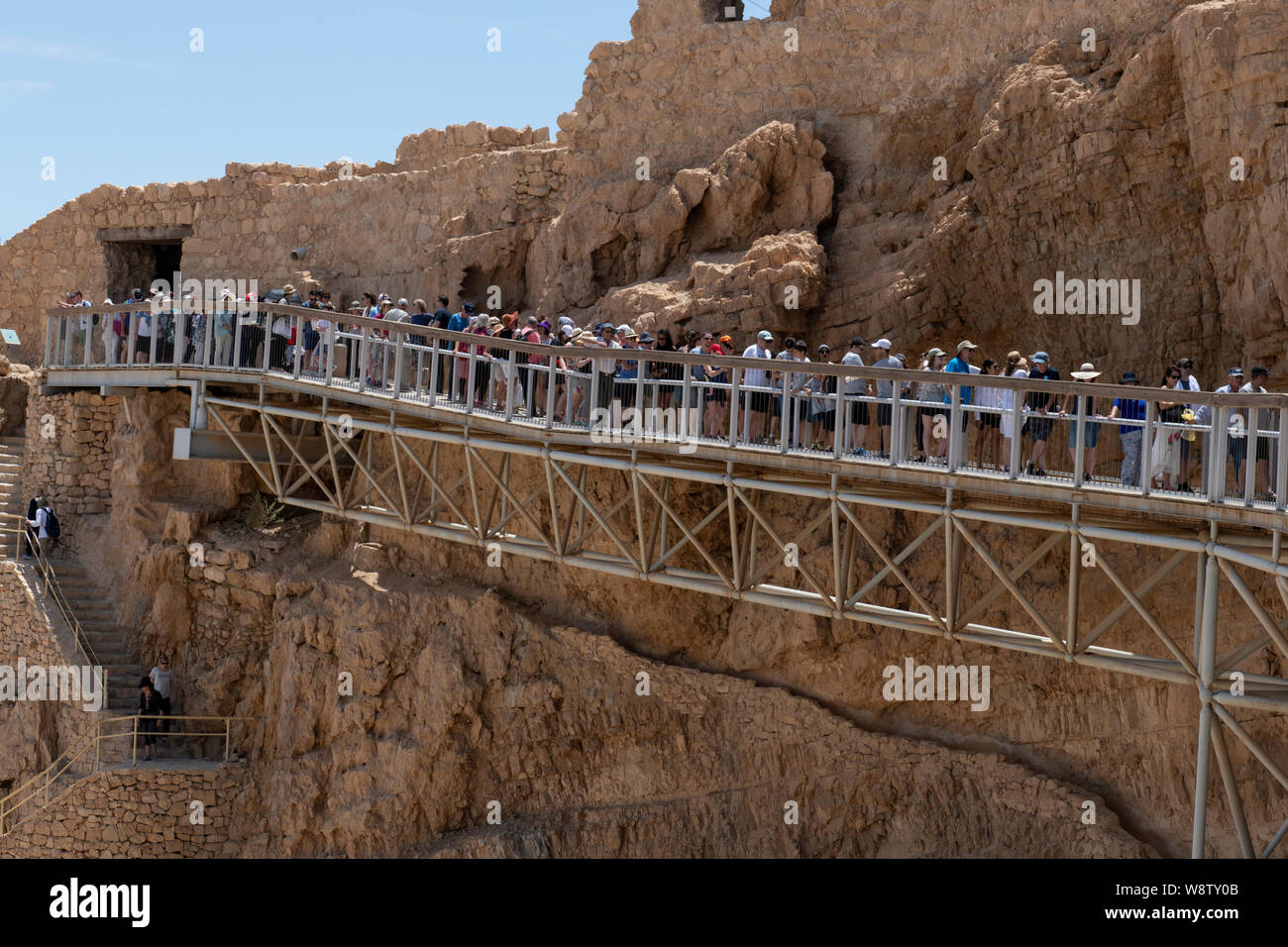 Israel, Masada National Park aka Massada. Pedestrian walkway near the cable car exit and Snake Path Gate at the summit. Line waiting for cable car. Stock Photo