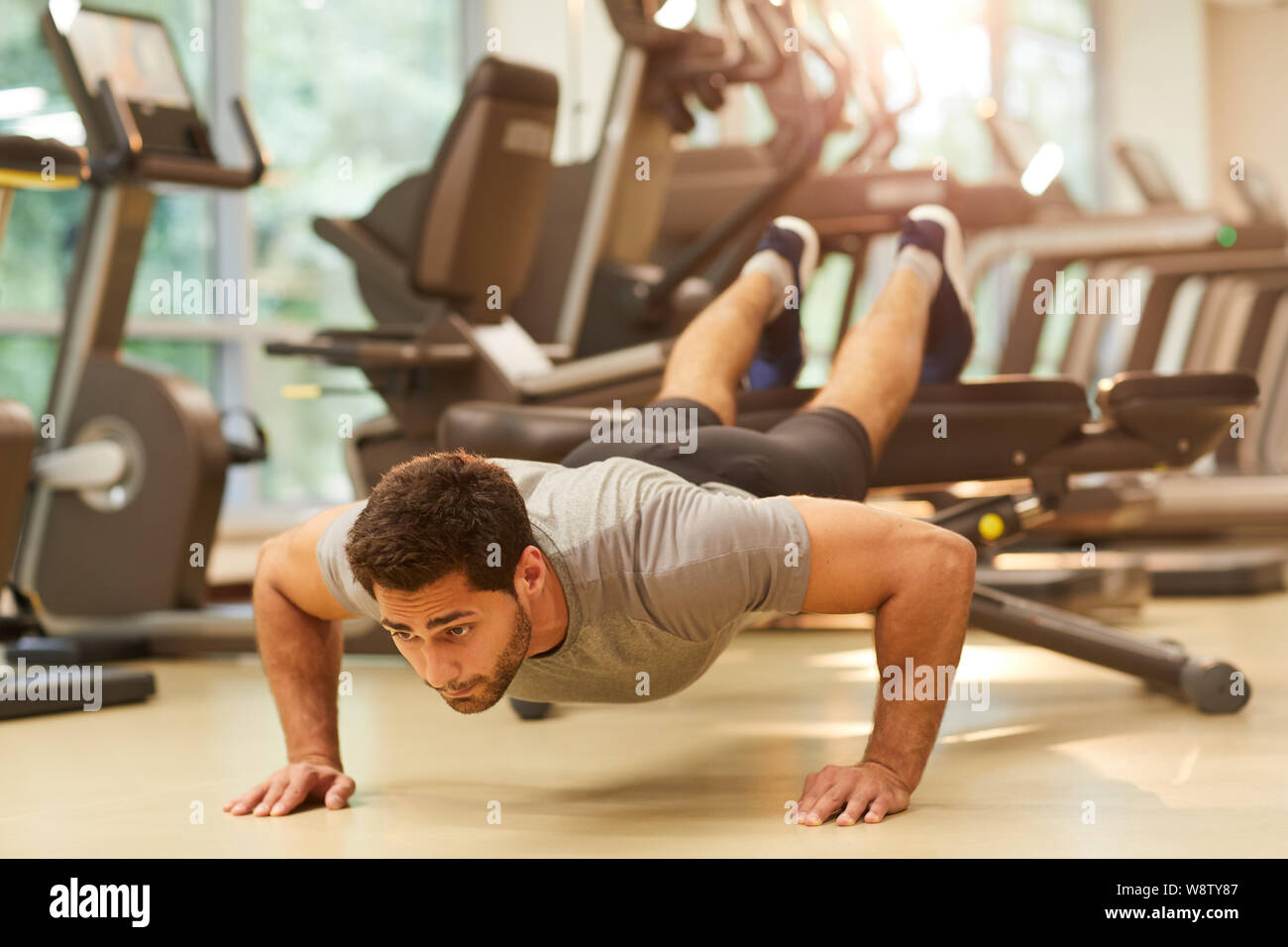 Full Length Portrait Of Muscular Man Doing Push Ups On Bench