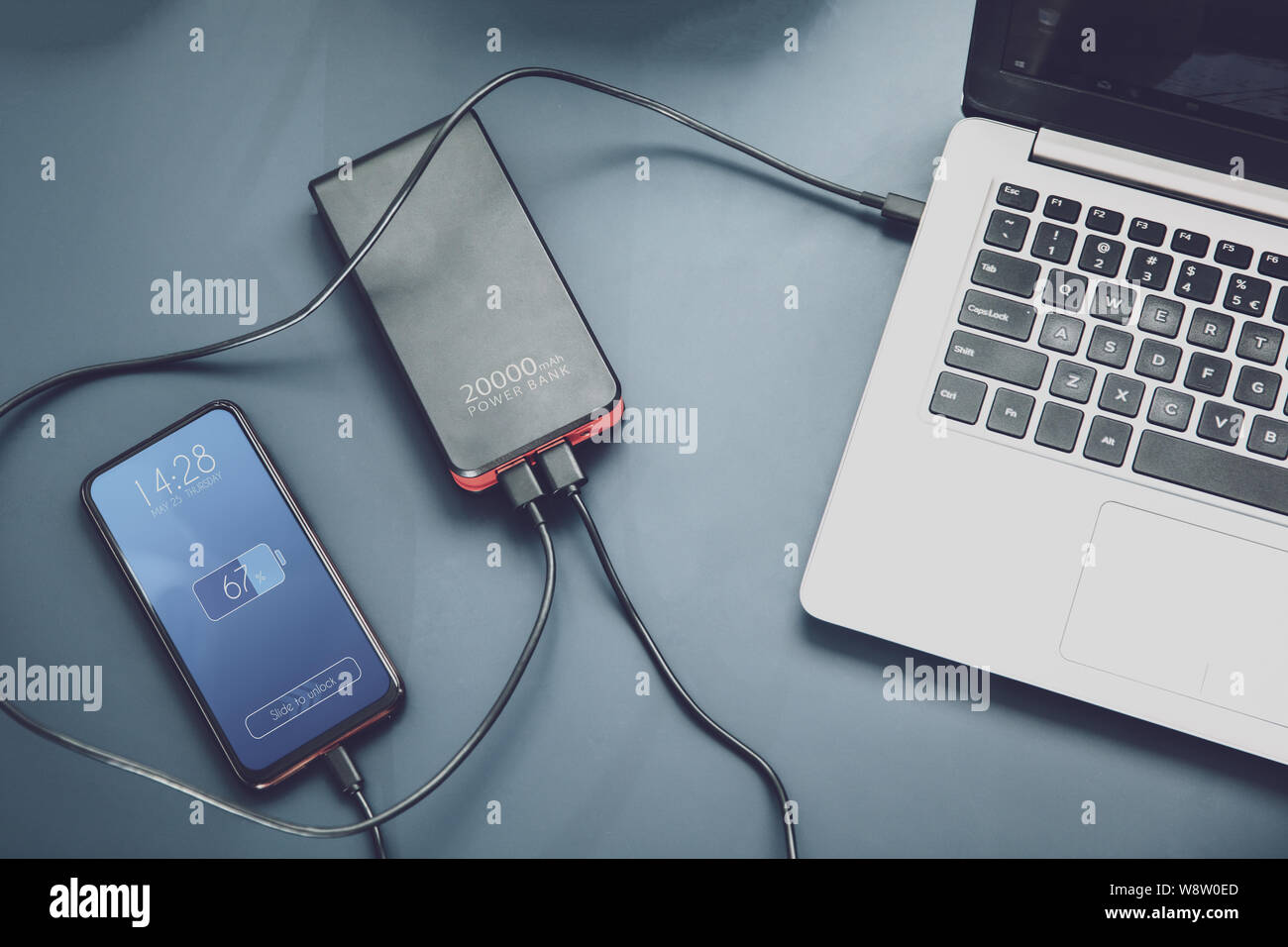 Powerfull power bank charges two devices at one time via USB-C connection. Interface on the screen was created in graphic program. Stock Photo