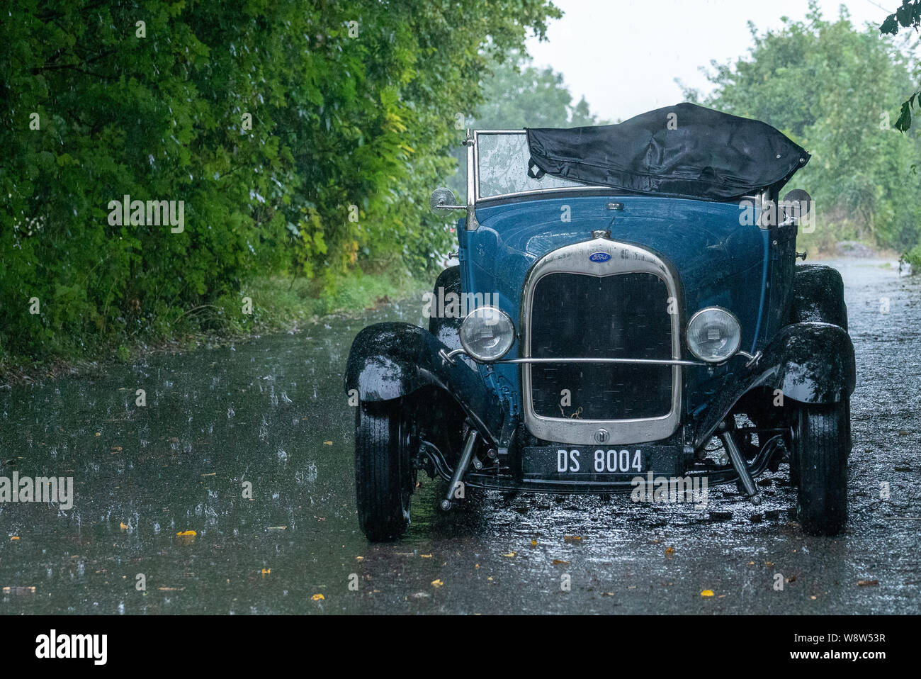 1929 Ford Roadster driver caught in heavy rain, Frome Somerset UK Stock Photo