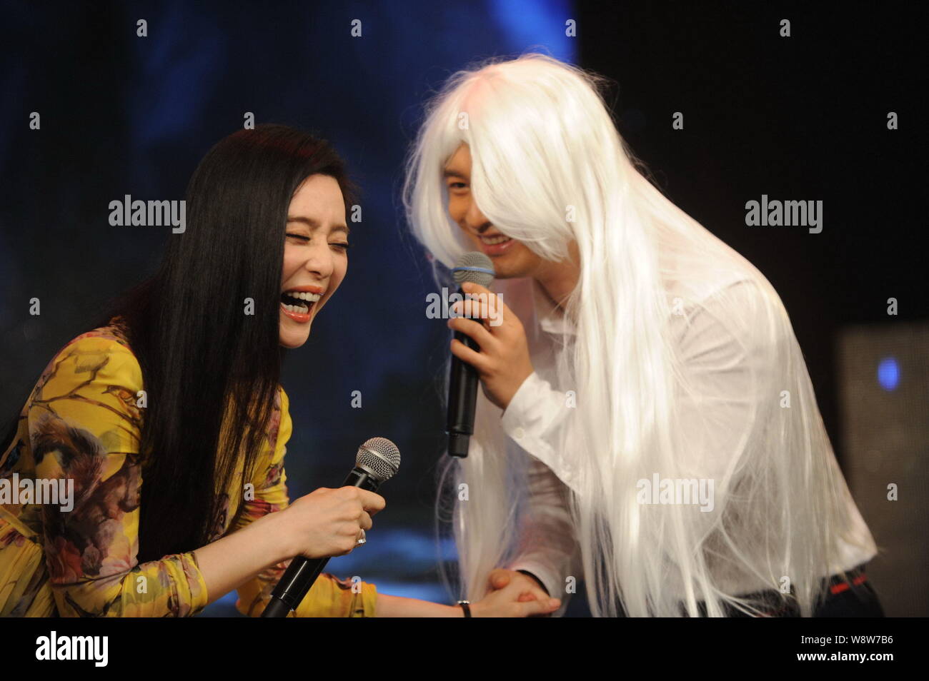 Chinese actor Huang Xiaoming, right, wearing a white wig and actress