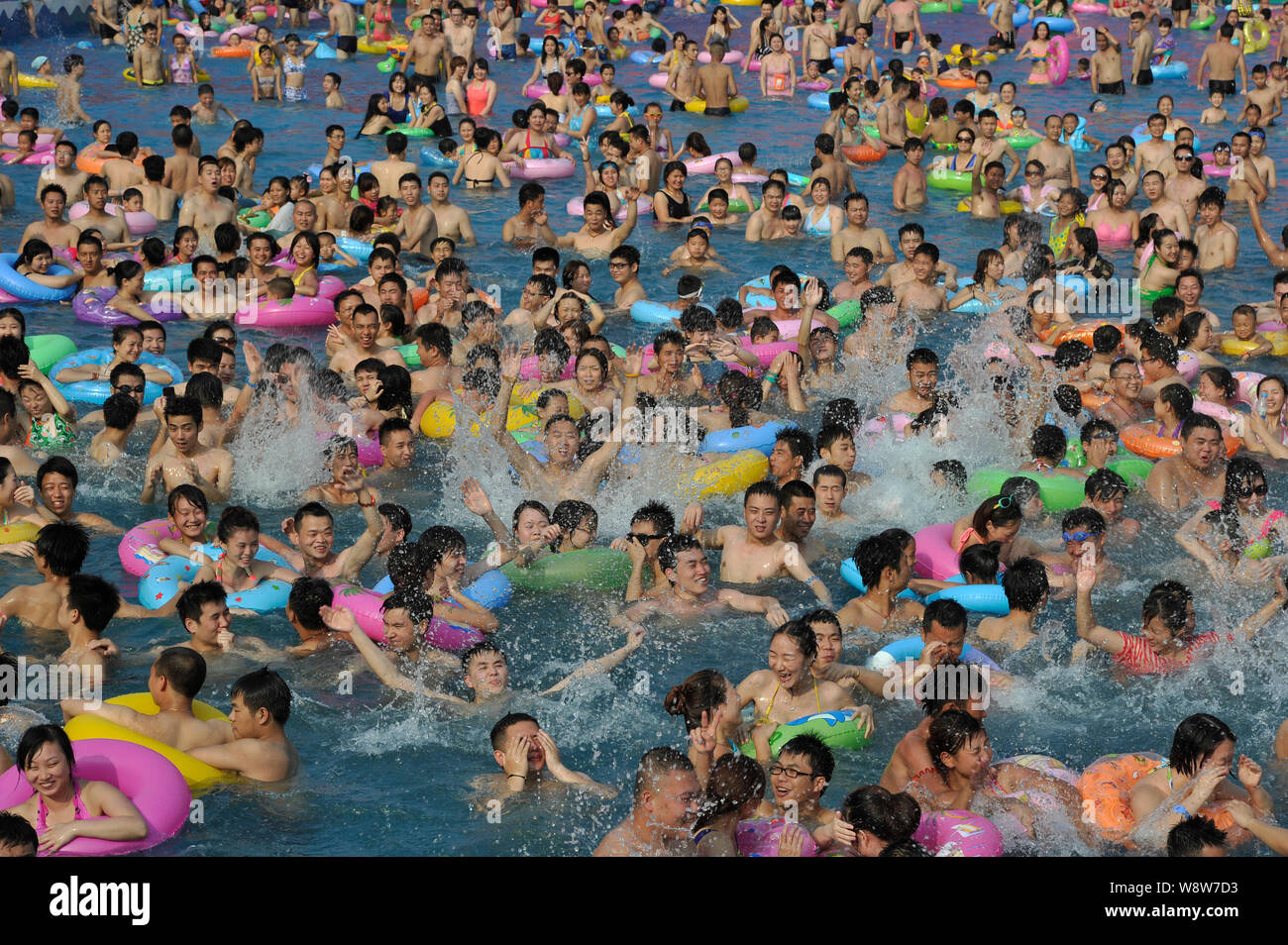 Holidaymakers crowd a swimming pool to cool down at a water park on a