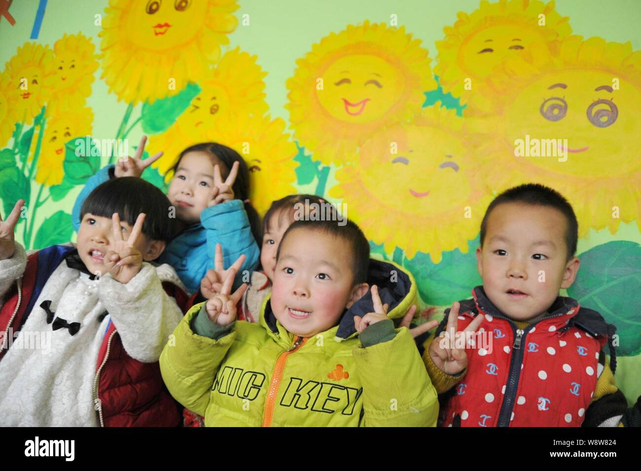 Young Chinese children left behind by their migrant worker parents play games at a rural kindergarten in Xinjiang county, Yuncheng city, north China's Stock Photo