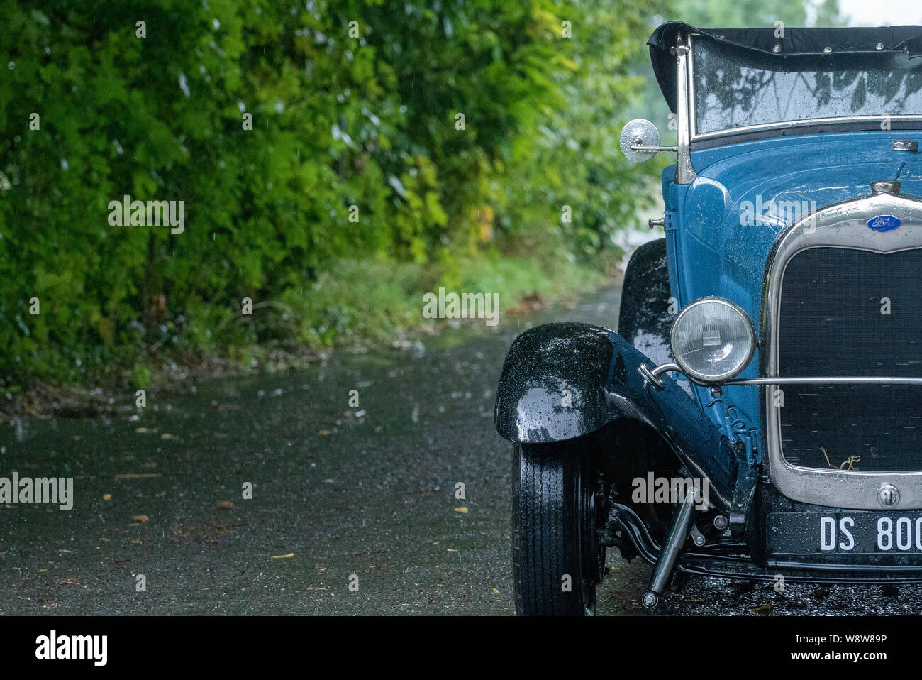 1929 Ford Roadster driver caught in heavy rain, Frome Somerset UK Stock Photo