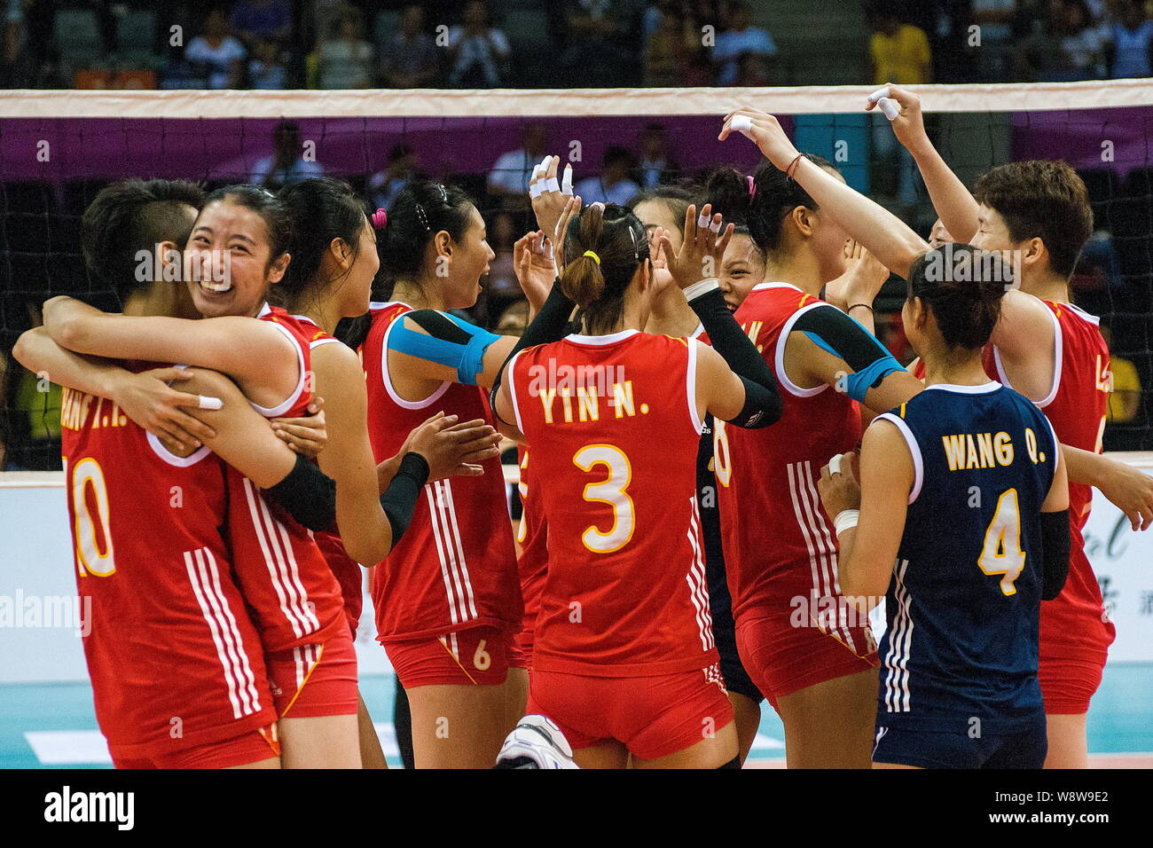 Members of the Chinese women's volleyball team celebrate after winning