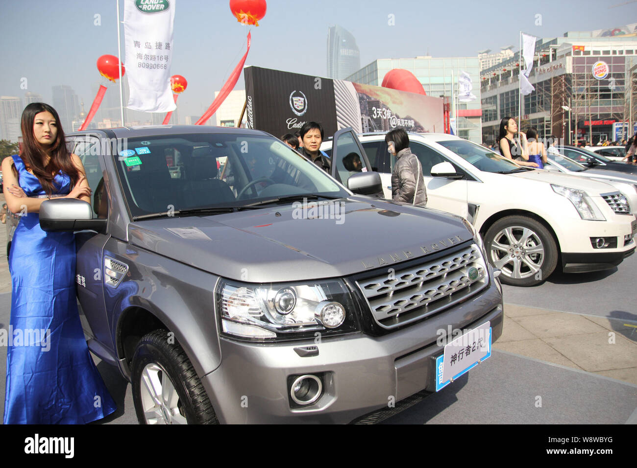 --FILE--A model poses with a Land Rover Freelander 2 of Jaguar Land Rover during an automobile exhibition in Qingdao city, east Chinas Shandong provin Stock Photo
