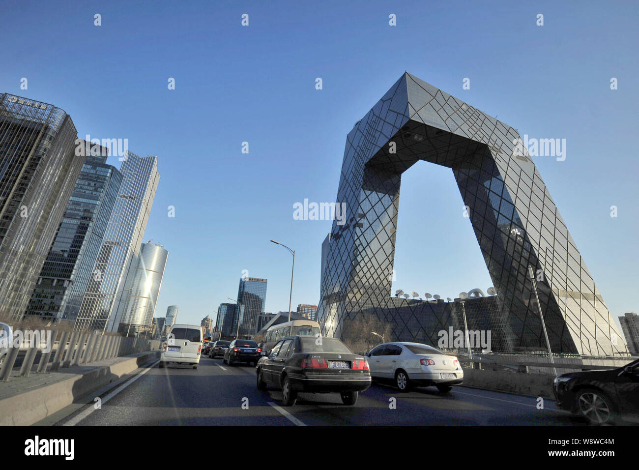 --FILE--Vehicles run past the CCTV (China Central Television) Tower in CBD (Central Business District) in Beijing, China, 27 February 2014.    For mon Stock Photo