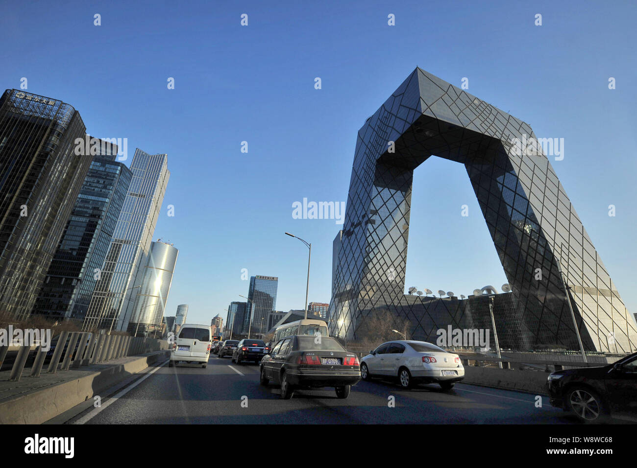 --FILE--Vehicles drive on an elevated highway next to the CCTV Tower, the headquarters of China Central Television, in CBD (Central Business District) Stock Photo