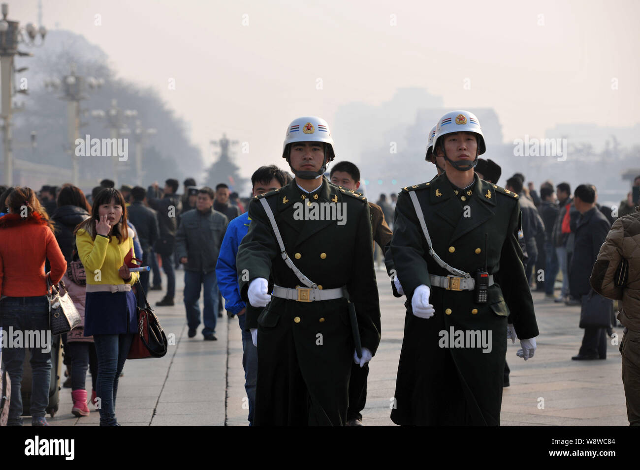 Chinese paramilitary policemen patrol past a crowd of tourists at the Tiananmen Square in Beijing, China, 2 March 2014.   Beijing has stepped up secur Stock Photo