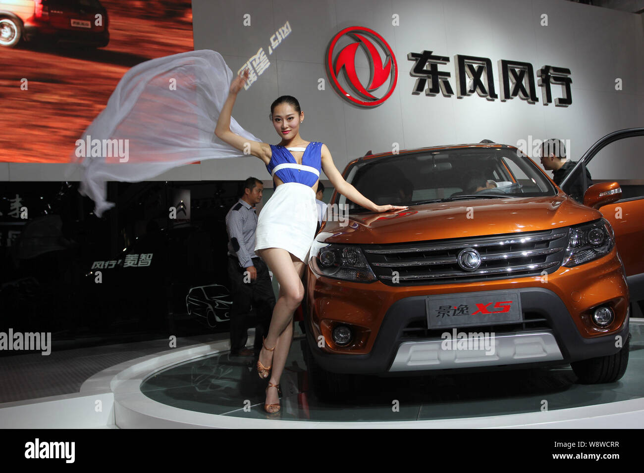 --FILE--A model poses with a car of Dongfeng Motor Corporation (DFM) during an exhibition in Wuhan city, central Chinas Hubei province, 19 October 201 Stock Photo