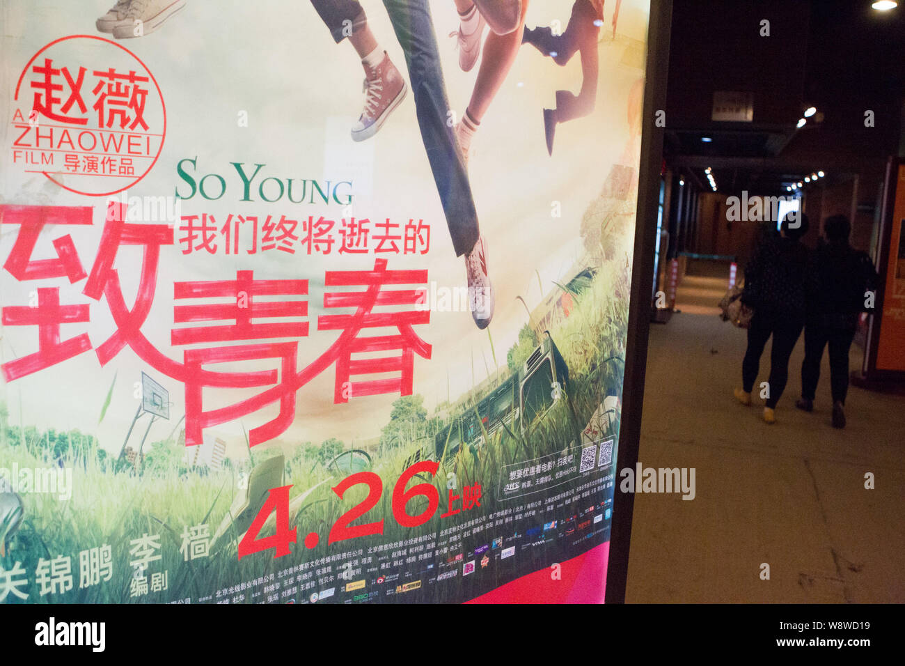 --FILE--Moviegoers walk past a poster for the movie, So Young, at a cinema in Shanghai, China, 2 May 2013.    Ke Liming, the 32-year-old producer of C Stock Photo