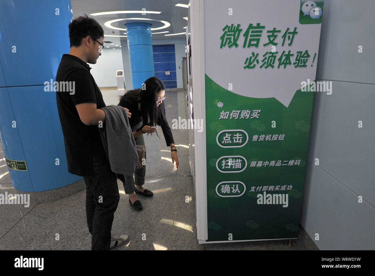 --FILE--Chinese customers buy bottled drinks on a vending machine by the Wechat app at a subway station in Beijing, China, 26 September 2013.   WeChat Stock Photo