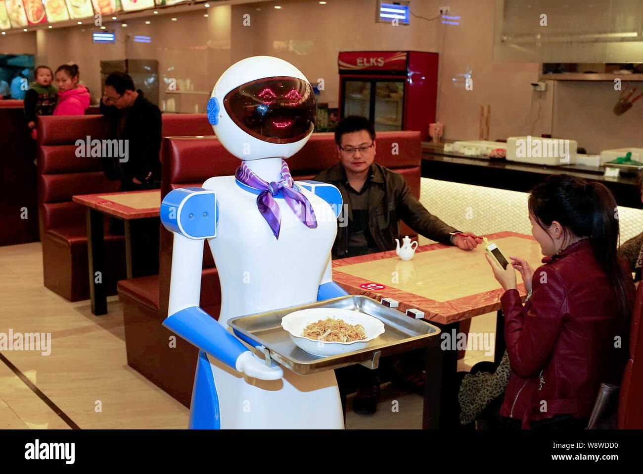 A robot waiter delivers food at a restaurant in Cixi city, east China's Zhejiang province, 27 November 2014.   A Chinese restaurant fascinates the pub Stock Photo