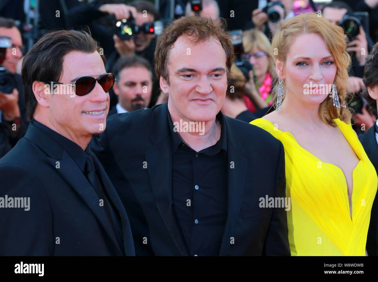 (From left) American actor John Travolta, Quentin Tarantino and actress Uma Thurman pose at a premiere for the movie, Clouds of Sils Maria, during the Stock Photo