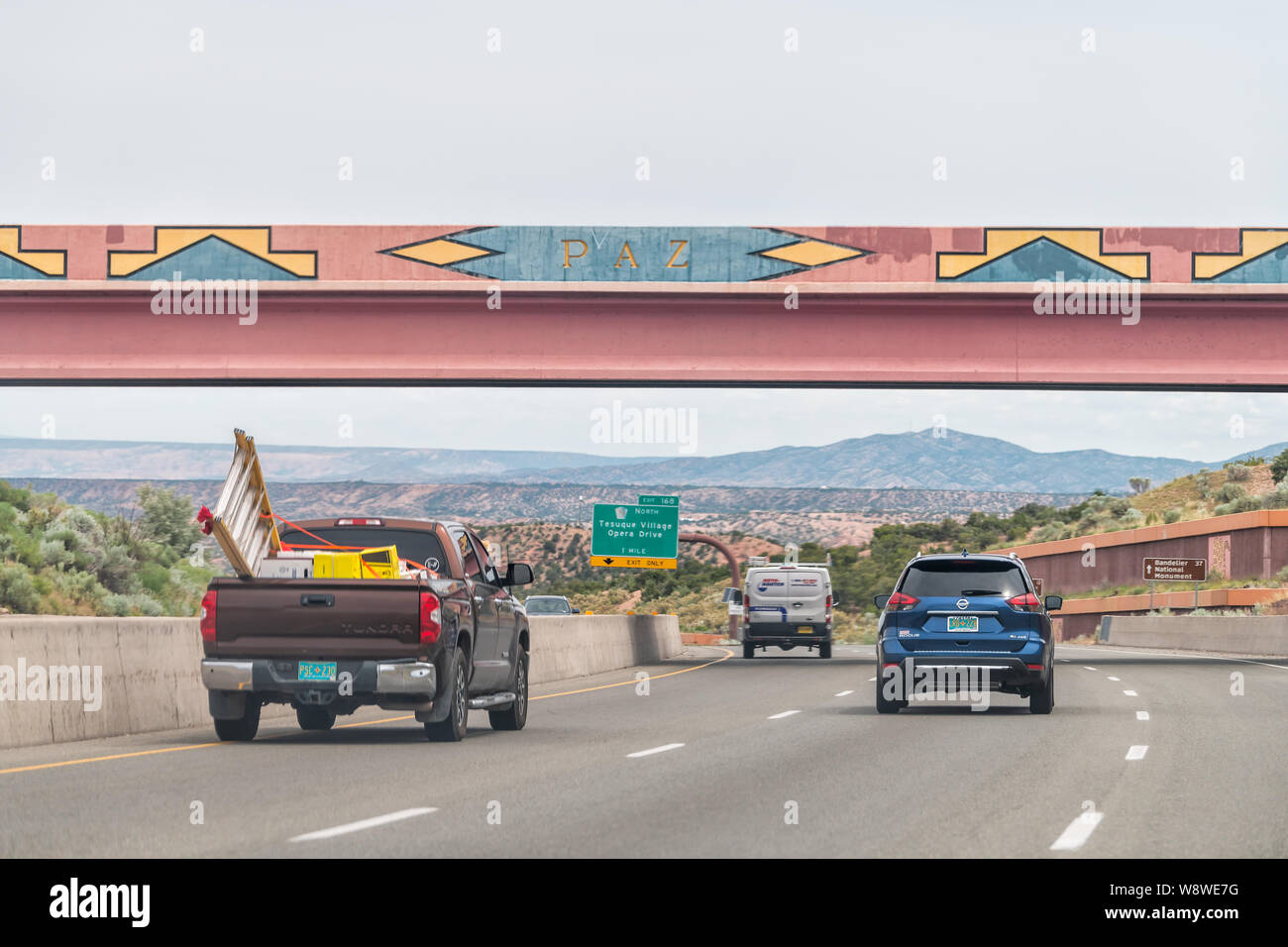 Santa Fe, USA - June 17, 2019: Cars on road US Highway 285 in New Mexico with decorations design colorful artwork on walls Stock Photo