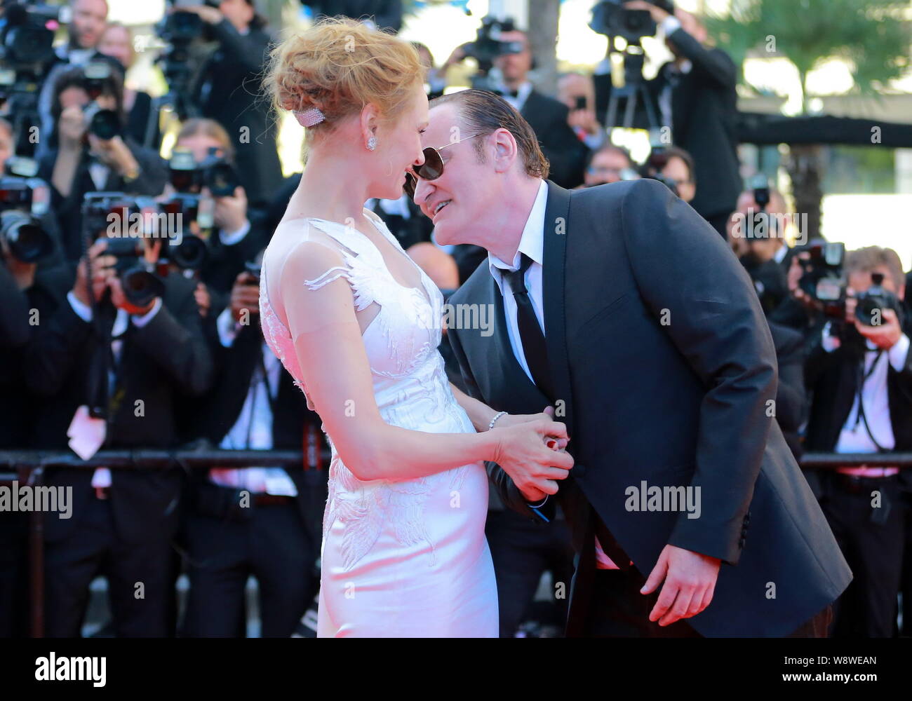 American director Quentin Tarantino, right, whispers to actress Uma Thurman as they arrive at the red carpet for the closing ceremony of the 67th Cann Stock Photo