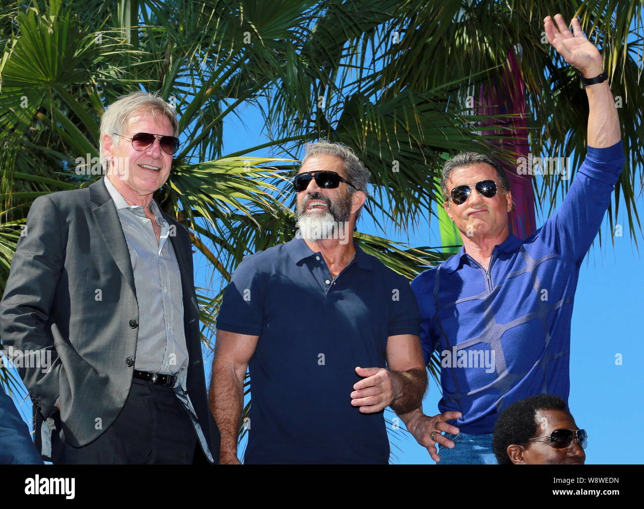 (From left) American actor Harrison Ford, Mel Gibson and Sylvester Stallone pose on a tank at a