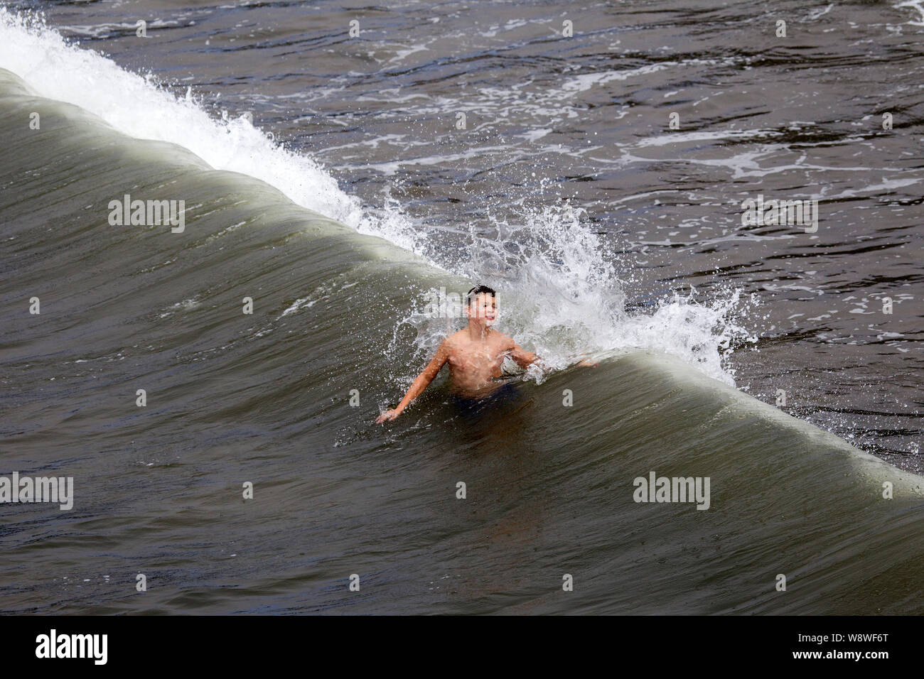 Ocean Wave Breaking on a Young Boy Stock Photo